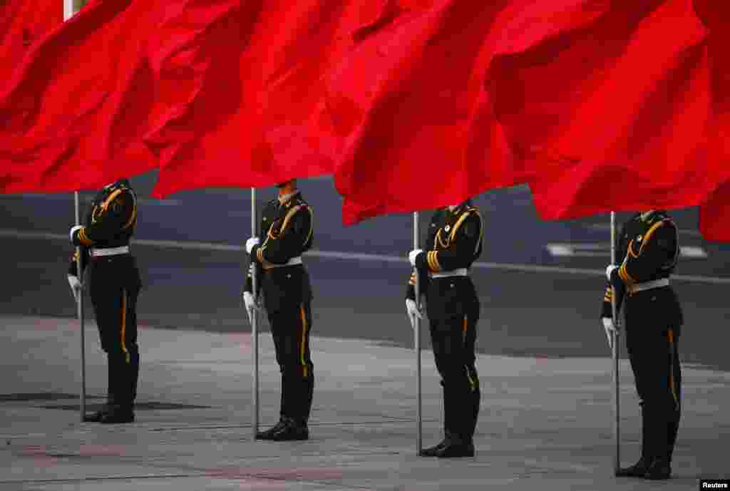 Pasukan kehormatan China memegang bendera yang menutupi wajah mereka, di depan Lapangan Tiananmen Beijing, selama upacara resmi untuk menyambut Presiden Serbia Tomislav Nikolic di luar Balai Agung Rakyat di Beijing.