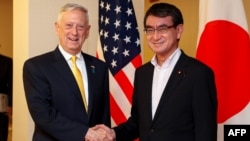 Menteri Pertahanan AS James Mattis, kiri, berjabat tangan dengan Menteri Luar Negeri Jepang Taro Kono di Tokyo, 29 Juni 2018.