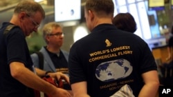 Passengers wearing self-designed T-shirts which celebrate their trip on Singapore Airline's inaugural non-stop flight to New York, wait at the check-in counter in Singapore, Oct. 11, 2018. 