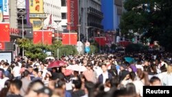 Chinese national flags are seen as tourists throng the Nanjing pedestrian road, a main shopping area, on China's 69th National Day in Shanghai, China, Oct. 1, 2018.