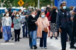 FILE - People arrive at Jackson Memorial Hospital to receive the COVID-19 vaccine in Miami, Jan. 6, 2021.