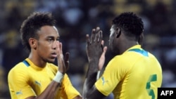 Pierre Emeric Aubameyang (G) na Bruno Ecuele Manga, basani babale ba Gabon, bapesani mbote na match na Sudan na CAN, na Franceville, Gabon, 12 janvier 2021.