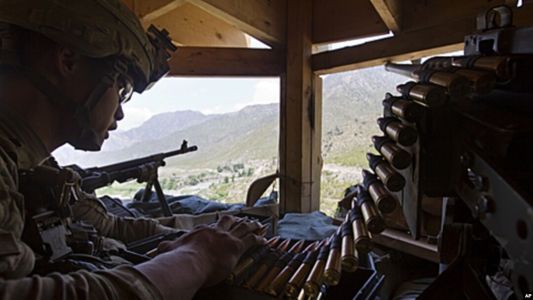 Staff Sergeant Benjamin George, 26, of Kalihi, Hawaii, stands guard in a watchtower at Combat Outpost Pirtle King in Kunar province, Afghanistan, July 6, 2011