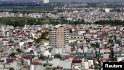 FILE - An apartment building under construction (C) is seen surrounded by older residential houses in Hanoi July 1, 2015.