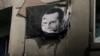 (FILE) A picture of Bashar al-Assad, damaged by bullets, hangs on the wall of a burnt building of Criminal Security department in Damascus, Syria, December 20, 2024.