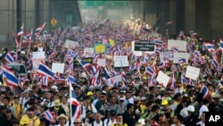 Waving flags and placards, Thai anti-government protesters make their way on a street during a march rally from the government complex on the outskirts of the capital to downtown Bangkok, Thailand, Dec. 9, 2013.