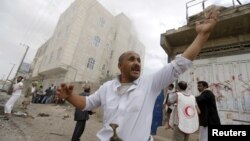 People react at the site of a Saudi-led coalition airstrike in Sana'a, Yemen, April 8, 2015. 