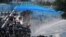 FILE - In this Sept. 15, 2019, photo, police fire water cannons at pro-democracy protesters outside the government headquarters in Hong Kong.