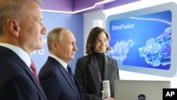 El presidente ruso, Vladimir Putin, al centro, y el consejero delegado de Sberbank, German Gref, izquierda, visitan una exposición de una conferencia sobre inteligencia artificial de AI Journey, el viernes 24 de noviembre de 2023, en Moscú, Rusia.