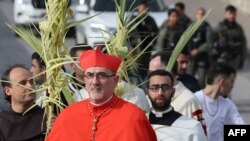 FILE—Pierbattista Pizzaballa, Latin Patriarch of Jerusalem, marches down a road, overlooking the Dome of the Rock mosque at the al-Aqsa mosque complex, during the traditional Palm Sunday procession at the Mount of Olives in Jerusalem on March 24, 2024.