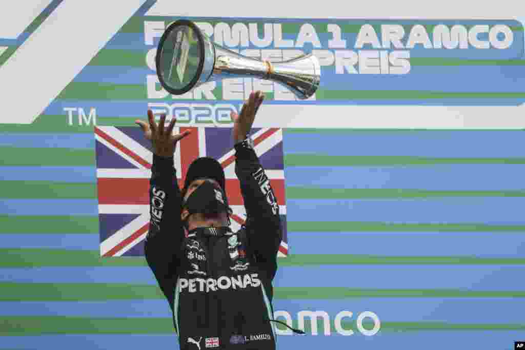 Mercedes driver Lewis Hamilton of Britain celebrates after winning the Eifel Formula One Grand Prix at the Nuerburgring racetrack in Nuerburg, Germany.