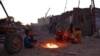 Children warm by the fire at a makeshift camp for displaced Palestinians in the Nahr al-Bared area in Khan Yunis, in the southern Gaza Strip, Dec. 9, 2024.