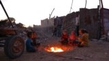 Children warm by the fire at a makeshift camp for displaced Palestinians in the Nahr al-Bared area in Khan Yunis, in the southern Gaza Strip, Dec. 9, 2024.