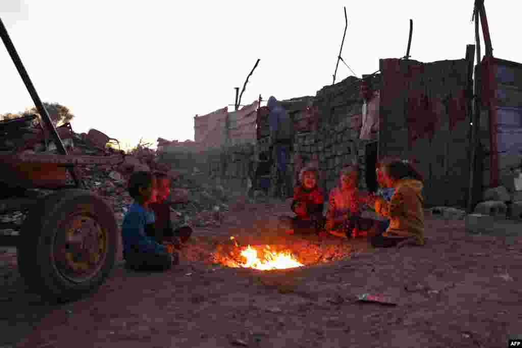 Children warm by the fire at a makeshift camp for displaced Palestinians in the Nahr al-Bared area in Khan Yunis, in the southern Gaza Strip.