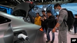 Sejumlah pengunjung tampak memperhatikan kendaraan listrik Geely Galaxy E8 EV dalam pameran otomotif Auto China 2024 di Beijing pada 28 April 2024. (Foto: AP/Andy Wong)