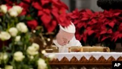 Pope Francis bows over the altar as he celebrates an Epiphany mass at St. Peter's Basilica, at the Vatican, Jan. 6, 2022. 