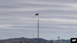 FILE - A North Korean flag flutters in the wind atop a tower in North Korea's village of Gijungdongseen, as seen from the Taesungdong freedom village inside the demilitarized zone in Paju, South Korea, April 27, 2018. 