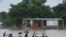 People ride on a boat through flooded waters in Sunamgong, Bangladesh, July 14, 2020.