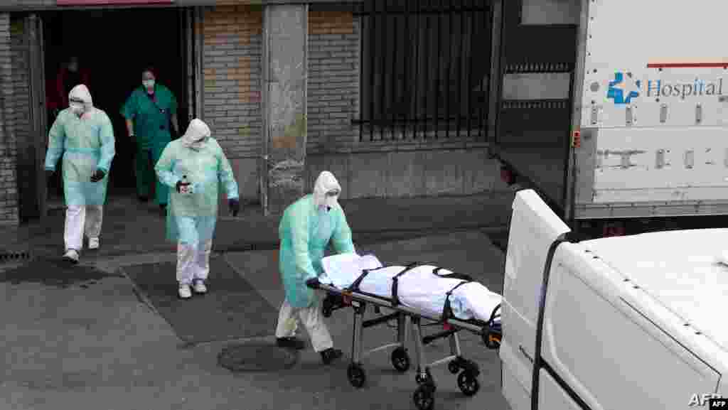 스페인 마드리드의 병원에서 의료 관계자들이 신종 코로나바이러스 감염증(COVID-19) 확진자 시신을 들것으로 실어 나르고 있다. 