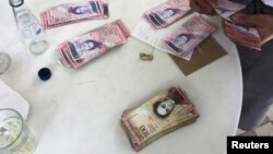 Seorang pelayan restoran menghitung pembayaran menggunakan uang kertas bolivar di Caracas, Venezuela (foto: ilustrasi). Pemerintah Venezuela menarik pecahan uang kertas 100 bolivar.