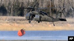 A National Guard helicopter picks up water from a farm pond near Hutchinson, Kansas, March 7, 2017.