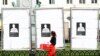 A woman walks past election campaign billboards in front of the European Parliament in Brussels, Belgium, April 30, 2019. 