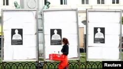 Seorang perempuan mengamati billboard kampanye di depan parlemen Eropa di Brussels, Belgia (30/4).