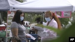 Una promotora de CASA, un grupo activista hispano, busca voluntarios latinos para probar una posible vacuna contra el COVID-19, en un mercado de Takoma Park, Maryland, el 9 de septiembre de 2020.