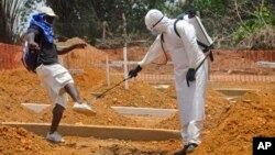 A man is sprayed with disinfectant after he celebrated the memory of a loved one who died due to the Ebola virus at a newly built grave yard for Ebola virus victims in Monrovia, Liberia, Wednesday, March 11, 2015. Liberians held a church service Wednesday for families who lost members to Ebola to mark the country’s 99th celebration National Decoration Day, a holiday normally set aside for people to clean up and re-decorate the graves of their lost relatives. (AP Photo/Abbas Dulleh)