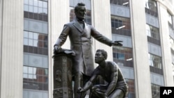 FILE - A statue that depicts a freed slave kneeling at Abraham Lincoln's feet rests on a pedestal, in Boston, June 25, 2020. Workers removed the Emancipation Memorial on Dec. 29, 2020, from a park just off Boston Common where it had stood since 1879. 