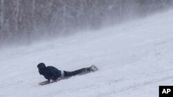 Un niño se divierte deslizándose con un trineo en una colina nevada después de una tormenta invernal en Kansas City, Missouri, el 9 de enero de 2023.