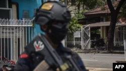 An Indonesian policeman stands guard at the site of an explosion outside a church in Makassar on March 28, 2021. 