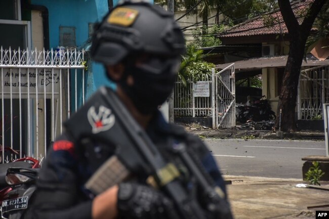 Seorang polisi berjaga di lokasi ledakan di luar sebuah gereja di Makassar pada 28 Maret 2021. (Foto: AFP/Indra Abriyanto)