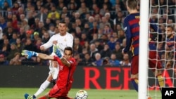 Cristiano Ronaldo marque le deuxième but du Real Madrid battant le gardien de Barcelone Claudio Bravo lors d'un match de football de La Liga espagnole surnommé «el clasico» opposant le Barcelone au Real Madrid, au stade Camp Nou à Barcelone, Espagne, 2 avril 2016.