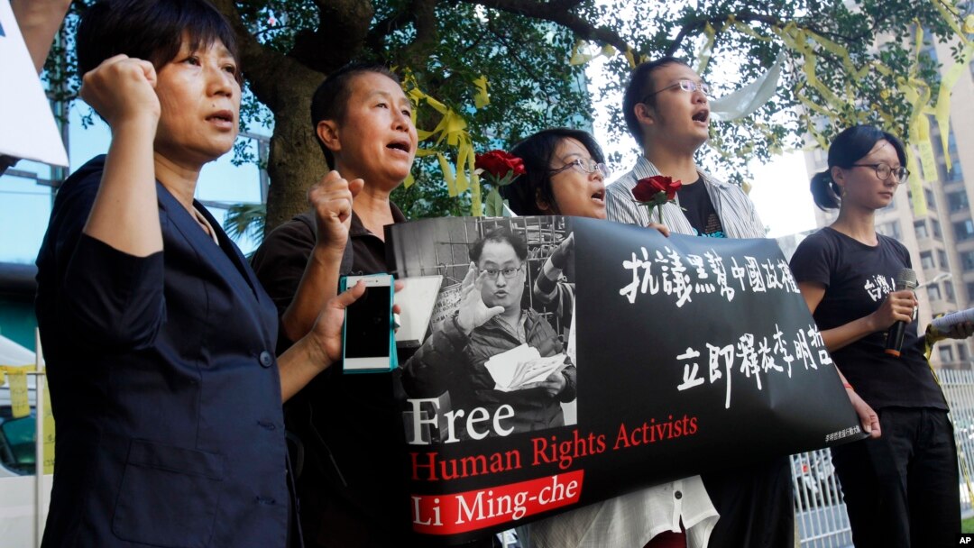 Supporters of Taiwanese activist Lee Ming-che detained in China, chant their support during a media event in Taipei, Taiwan, Nov. 28, 2017.