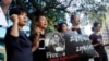 FILE - Supporters of Taiwanese activist Lee Ming-che detained in China, chant their support during a media event in Taipei, Taiwan, Nov. 28, 2017.