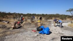 Researchers work at a site called Laetoli in northern Tanzania, where they found five fossilized footprints dating from 3.66 million years ago. Shirley Rubin/Handout via REUTERS