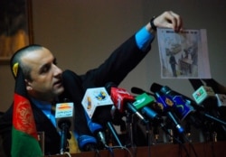 FILE - Amrullah Saleh, head of Afghanistan's intelligence service, holds a picture taken from the Serena Hotel's security cameras before the suicide attack on the hotel, during a news conference in Kabul, Jan. 15, 2008.