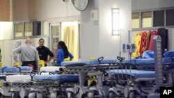 Emergency personnel wait with stretchers at the emergency entrance to Orlando Regional Medical Center hospital for the arrival of patients from the scene of a fatal shooting at Pulse Orlando nightclub in Orlando, Florida, June 12, 2016. 