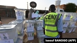 Les membres de la Commission électorale nationale indépendante (CENI) du Niger préparent les urnes et le matériel électoral avant de les envoyer aux bureaux de vote à la veille du second tour des élections dans le pays, à la Commune 2 de Niamey, le 20 février 2021.