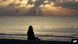 FILE - A woman meditates on the beach in Miami, Florida, April 28, 2010. According to a study published on Nov. 9, 2022 in the journal JAMA Psychiatry, mindfulness meditation worked as well as a standard drug for treating anxiety. (AP Photo/Lynne Sladky, File)