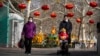 Seorang pria bersama anaknya di kereta dorong di sebuah taman di Beijing, 17 Januari 2023. (Foto: Mark Schiefelbein/AP Photo)