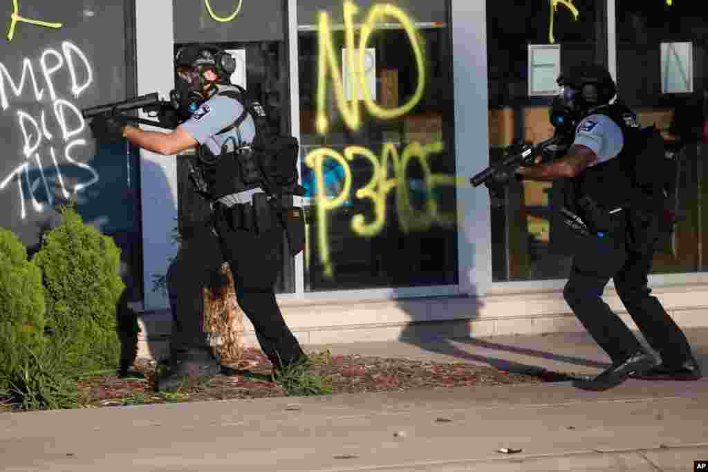 Minneapolis police work their way down a street, May 28, 2020, in St. Paul, Minn.