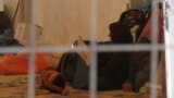 In this Saturday, Sept. 9, 2017 image made from video, a woman and a small child lie on the floor of a tent in a camp for displaced people on the outskirts of Mosul, Iraq. Over 1,300 women and children, all foreign nationals and relatives of Islamic Stat