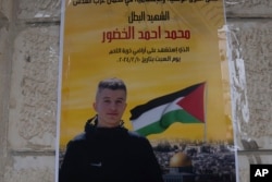 A poster with the name and picture of Mohammad Khdour, 17, reading "glory for the martyr hero who was martyred on Saturday February 10, 2024," is posted at the entrance to the family's house in the West Bank on Feb. 12, 2024.