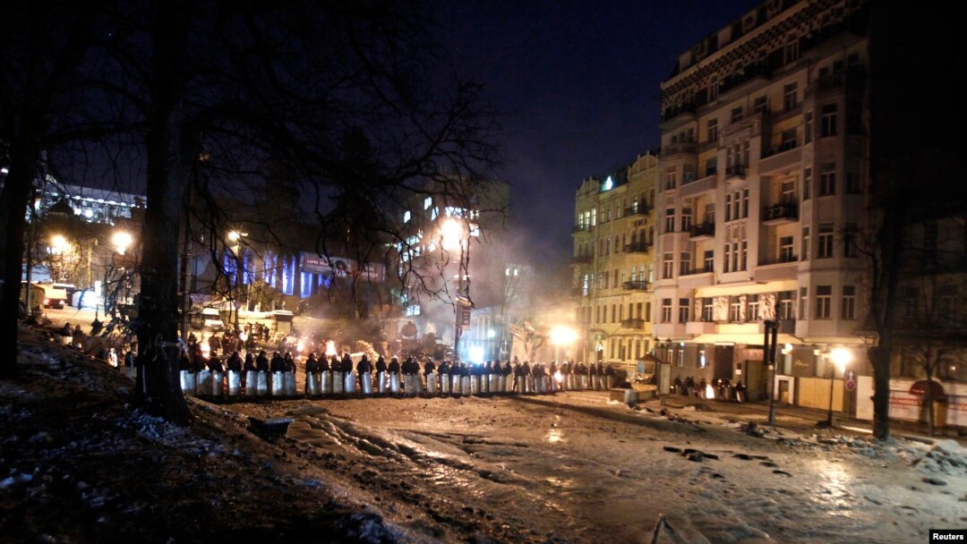 Riot police stand in a cordon facing a barricade of anti-government protesters in Kyiv, Feb. 3, 2014. 