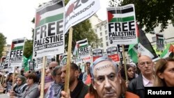 A demonstrator wears a Benjamin Netanyahu mask with a message written on it during a protest outside Downing Street in London, Britain Sept. 9, 2015. 