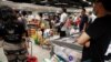 Warga memborong bahan makan di sebuah supermarket di Singapura karena khawatir terjadi kelangkaan setelah Malaysia mengumumkan penutupan perbtasan untuk mengatasi virus corona, 17 Maret 2020. (Foto: Reuters)