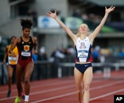 FILE - Arizona's Sage Watson, right, raises her arms in victory as she defeated Southern California's Anna Cockrell to win the women's 400 hurdles during the NCAA outdoor college track and field championships in Eugene, Ore., Saturday, June 10, 2017. (AP Photo/Timothy J. Gonzalez)