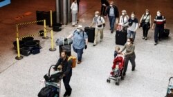 Passengers wearing face masks walk at the Helsinki-Vantaa airport in Vantaa, as Finnish Government has eased travel restrictions with several EU countries following the coronavirus disease (COVID-19) outbreak, in Finland, July 13 2020.